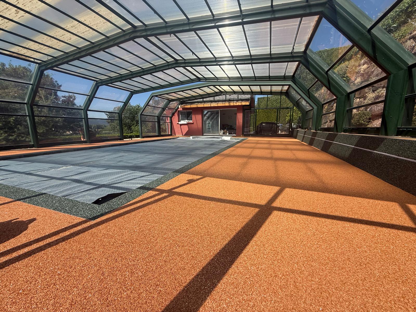 Moquette de pierre orange et vert sous un abri de piscine